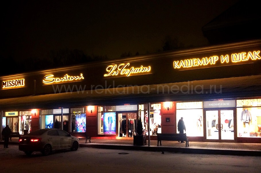 Ночной вид фасадных вывесок брендовых магазинов в Vnukovo Outlet Village